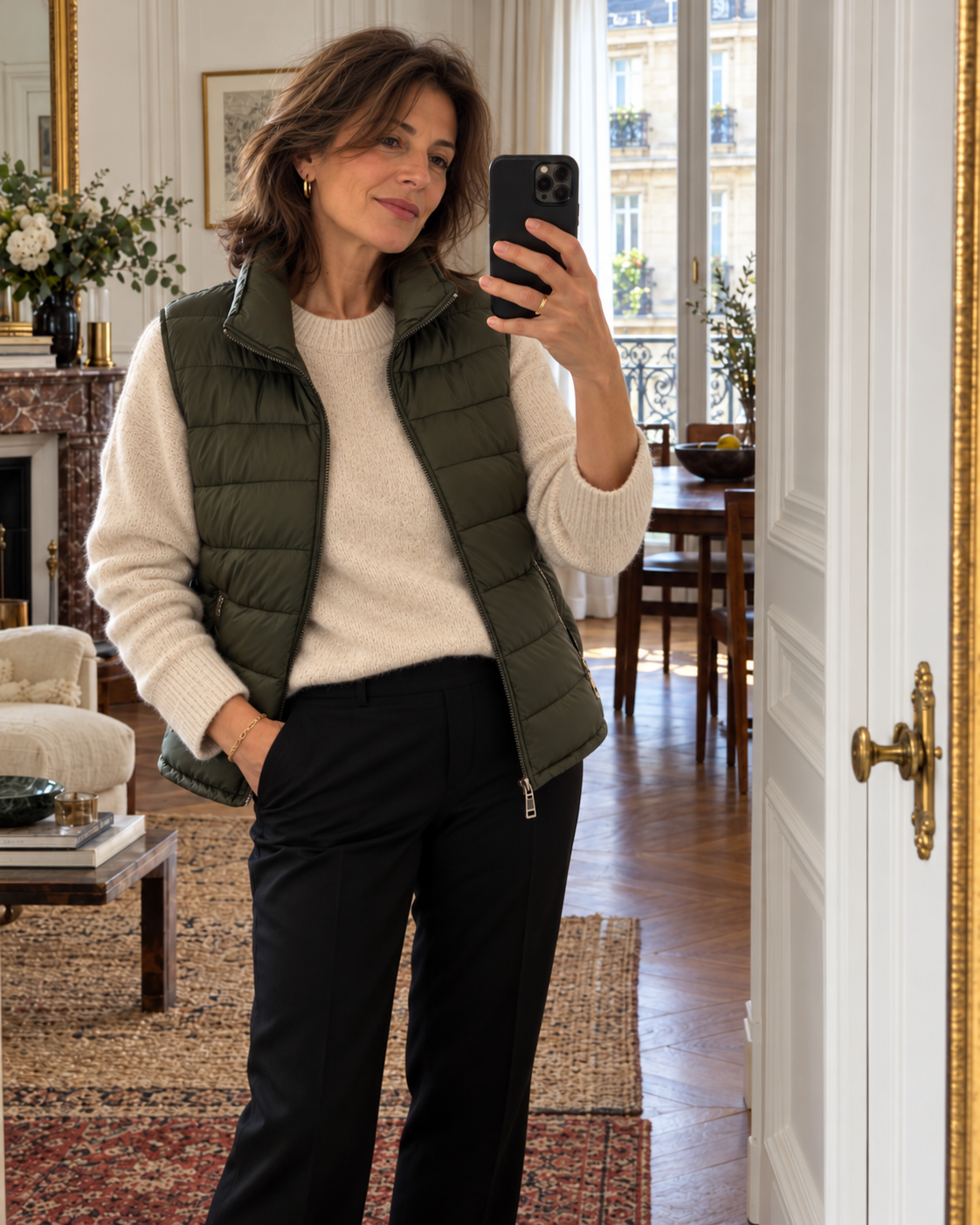 Femme brune portant une doudoune sans manches kaki sur un pull écru.